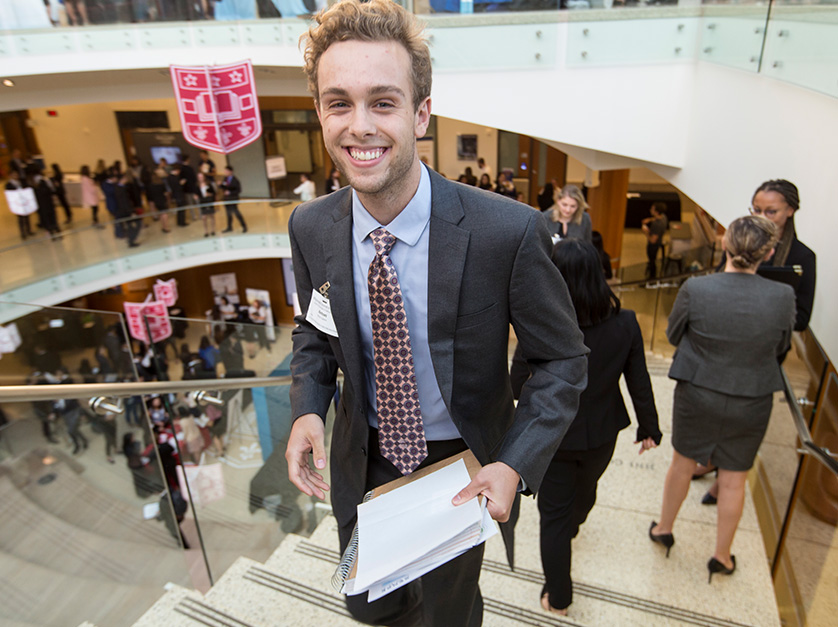 An Olin business student smiles while wearing a suit