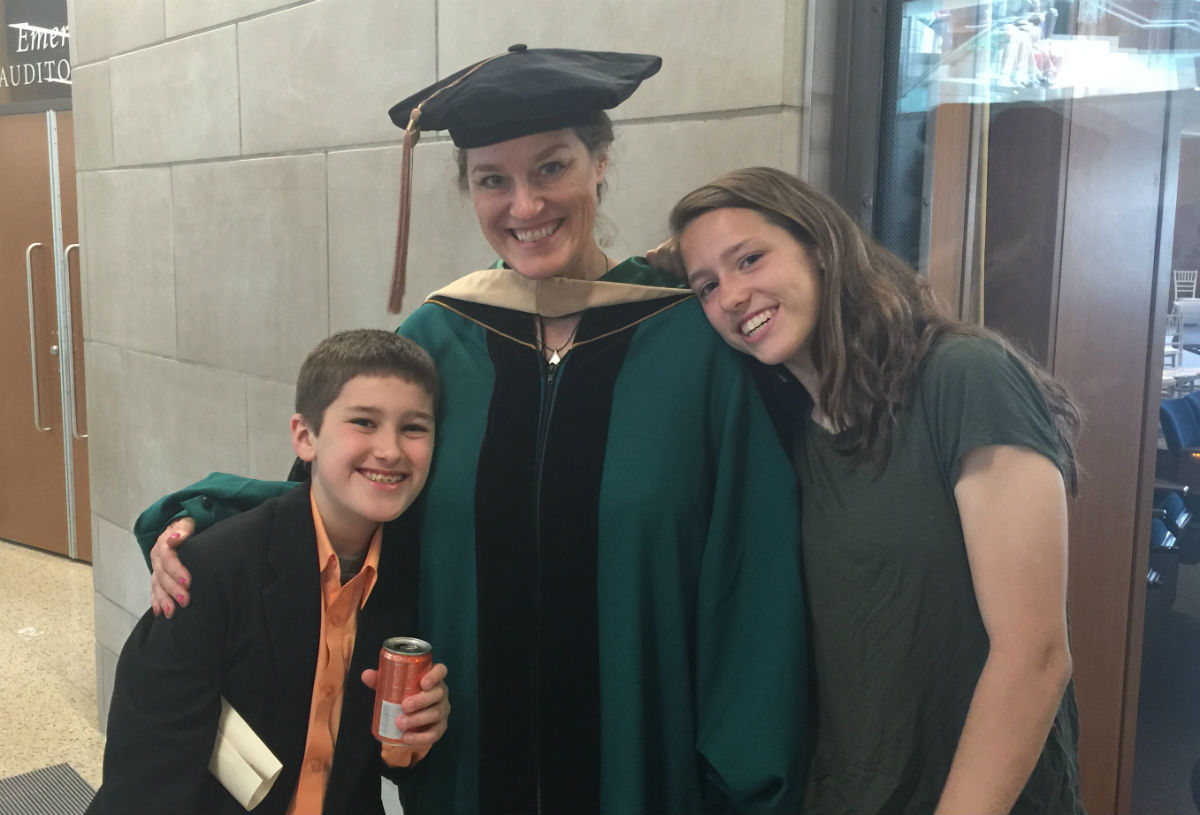 Cameron McKenzie, the author’s son, the author herself, and her daughter Maya McKenzie at the author’s EMBA graduation in May 2015.