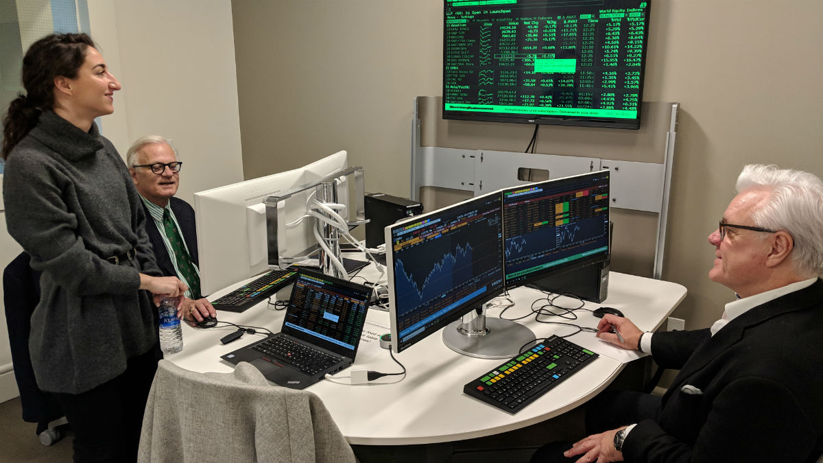 Timothy Solberg working on a terminal along with Dean Mark Taylor under the guidance of Bianca Simonetti, Bloomberg’s account manager for the St. Louis area.