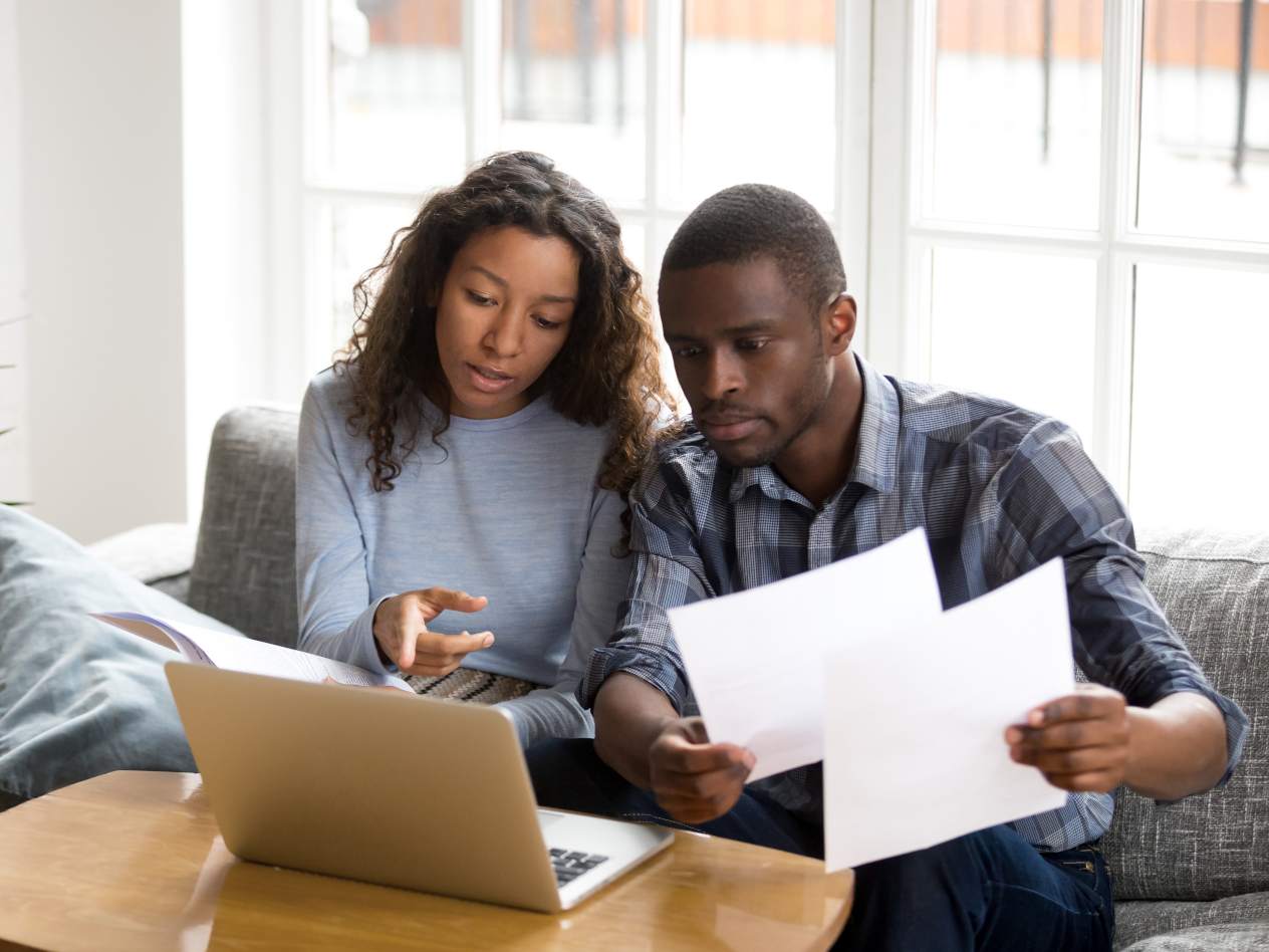 Couple at work in front of laptop with papers