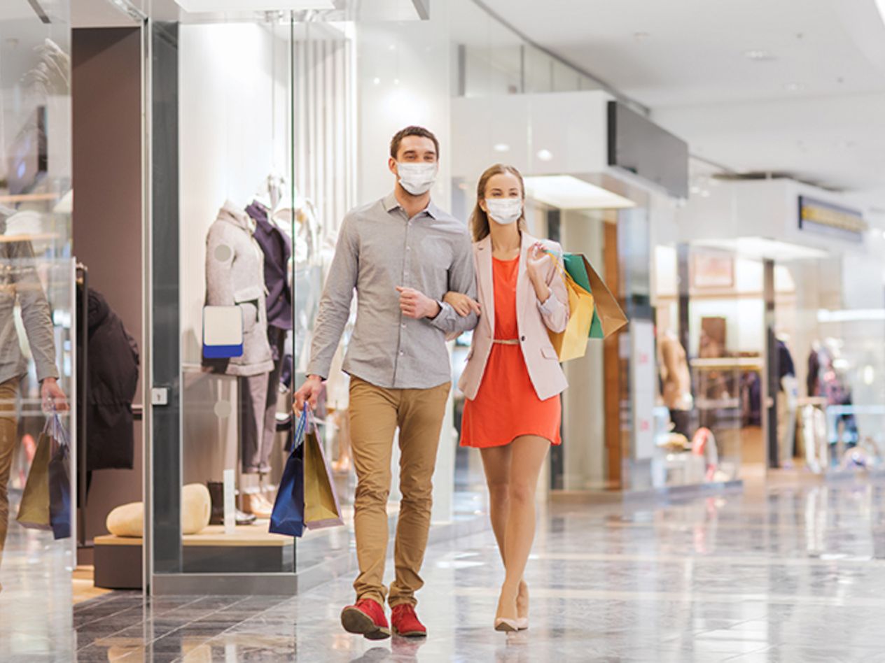 Shoppers in a mall wearing facemasks