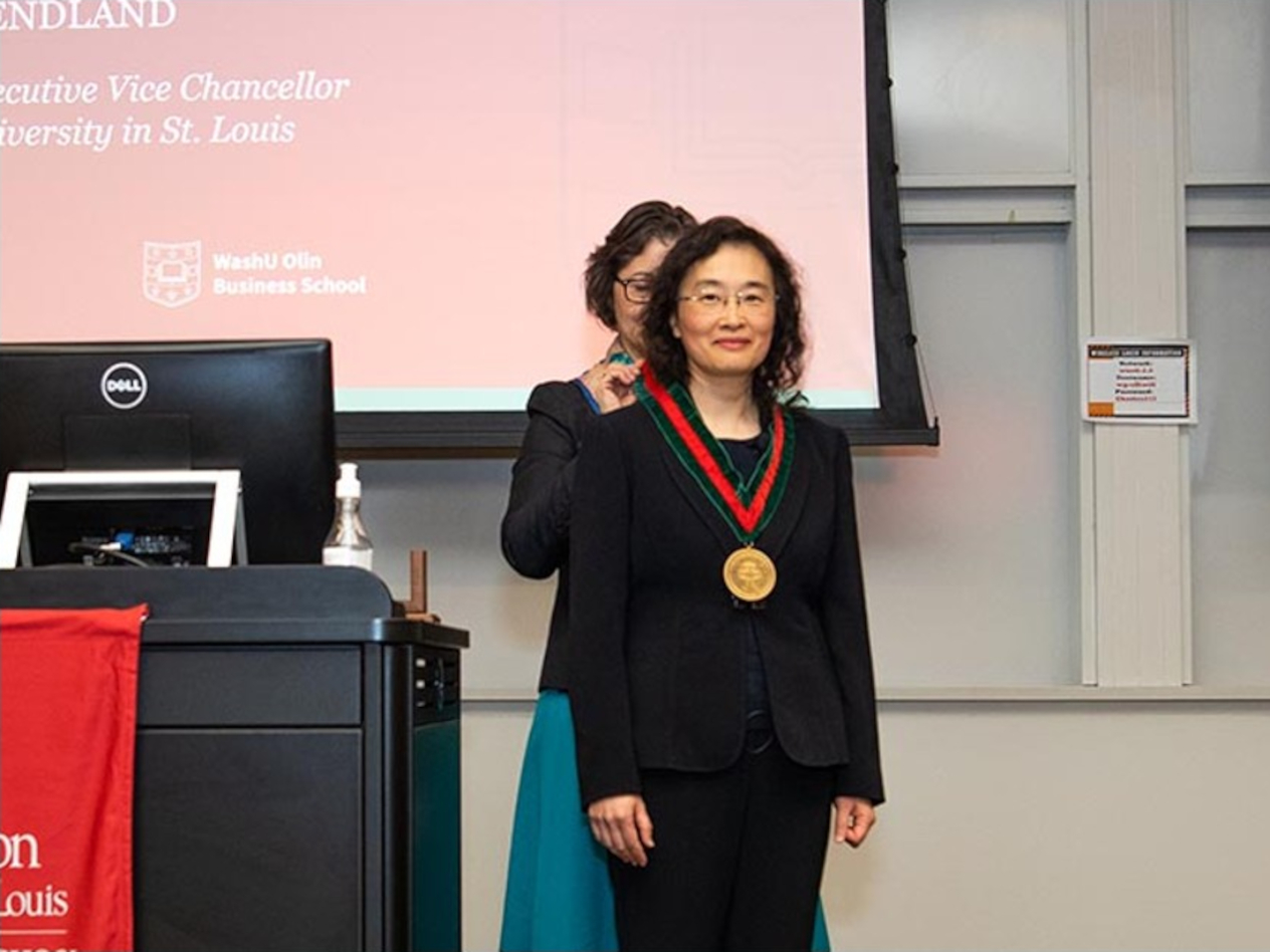 Above, Dong receives a medallion from Provost Beverly Wendland during her installation ceremony February 6. (Photo: Gara Lacy/Washington University)