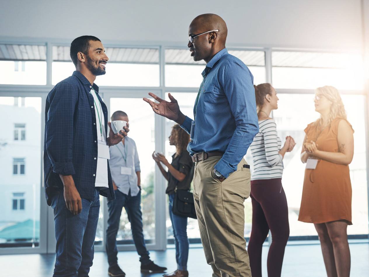 Young professionals standing and talking together at an event.