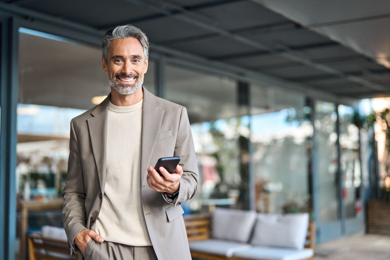 Graying, nicely dresses man with cellphone