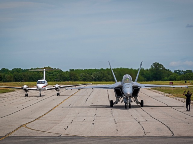 two planes taxiing on a runway